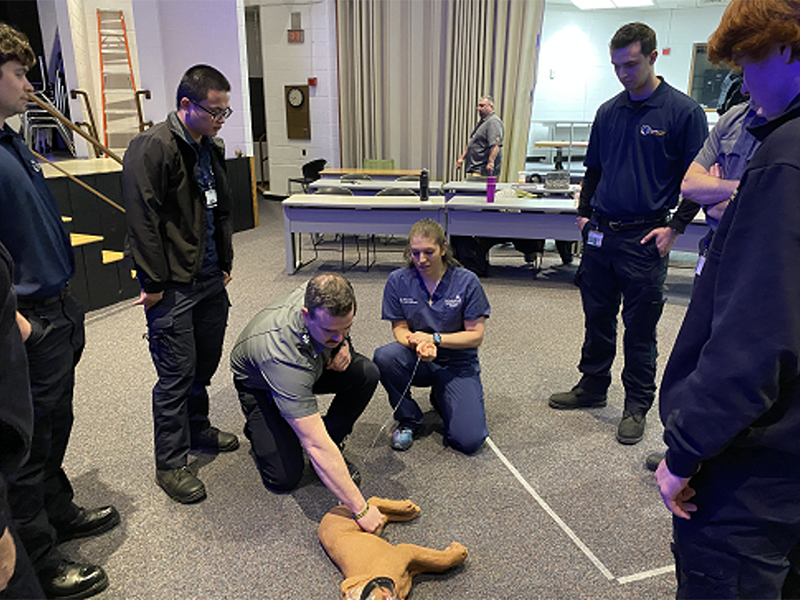 Veterinarian, Dr. Alexis Zallas, works with MassBay EMS students to learn how to find an accurate pulse on a dog mannequin, Framingham, MA, February 2023 (Photo/MassBay Community College). Veterinarian, Dr. Alexis Zallas, works with MassBay EMS students to learn how to find an accurate pulse on a dog mannequin, Framingham, MA, February 2023 (Photo/MassBay Community College).
