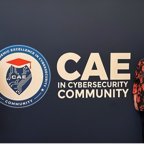 MassBay Faculty in front of CAE banner